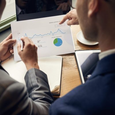 Business people analyzing visitors activity statistics, view over the shoulder